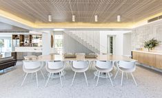 a dining room table surrounded by white chairs