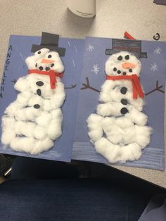 two snowmen made out of paper on a table