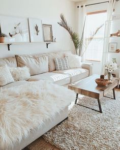 a living room filled with white furniture and lots of pillows on top of it's couches