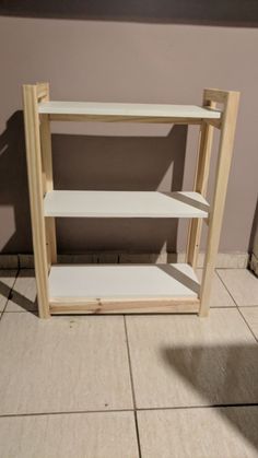 an unfinished shelf sitting on top of a tiled floor