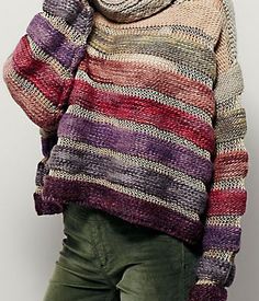 a woman wearing a multicolored sweater and green pants