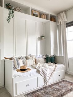 a white daybed with pillows and blankets on it