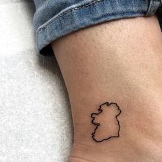 a small tattoo on the ankle of a woman's leg shows a map of england