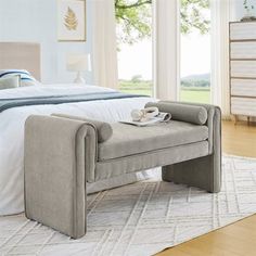 a bedroom with a large bed and white carpeted flooring next to a window