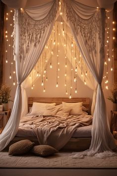 a bed with white drapes and lights hanging from the ceiling