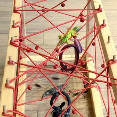 a close up of a wooden structure with ropes and rings on the bottom, along with other objects