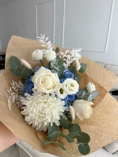 a bouquet of white and blue flowers on brown paper