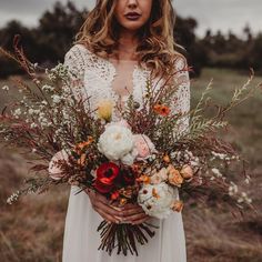 a woman holding a bouquet of flowers in her hands