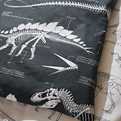 an image of a pillow that has dinosaurs on it and other things in the background