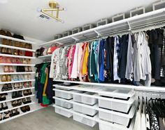 an organized closet with white shelving and shelves filled with shoes, t - shirts and other items