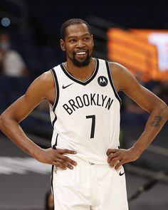 a basketball player is standing with his hands on his hips and looking at the camera