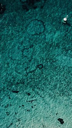 two small boats floating on top of the ocean next to each other in clear blue water