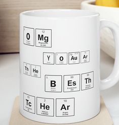 a white coffee mug with the elements of an element in it on top of a coaster