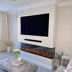 a living room with a large flat screen tv on the wall and a fire place