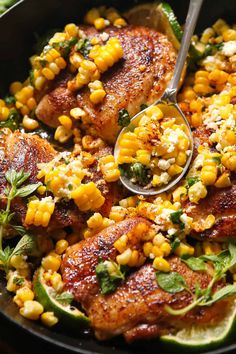 a skillet filled with chicken, corn and garnished with cilantro