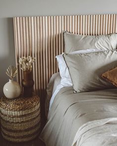 a bed that has some pillows on top of it and a basket next to it