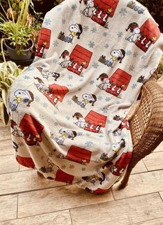 a chair covered in a blanket with snoopy characters on it and snowflakes