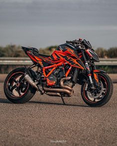 an orange and black motorcycle parked on the street