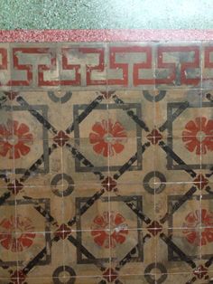 an old tiled wall with red and black designs