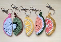 four crocheted keychains with fruits on them