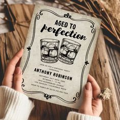 a person holding up a book with an image of two glasses on it and the title, aged to perfection