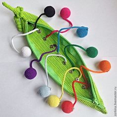 crocheted toys are laying on top of a green boat that is made out of yarn