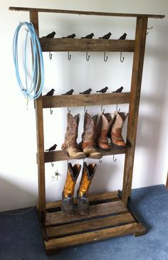 several pairs of boots are hanging on a wooden rack