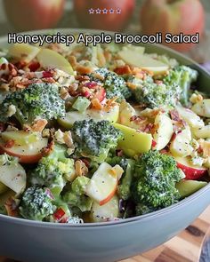 a close up of a bowl of food with broccoli and apples in it