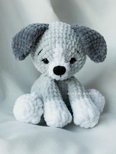 a crocheted stuffed dog sitting on top of a white sheet