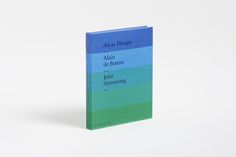 a book with blue, green and purple covers on the cover is sitting in front of a white background