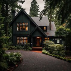 a large house with lots of windows and trees around it's front entrance, surrounded by greenery