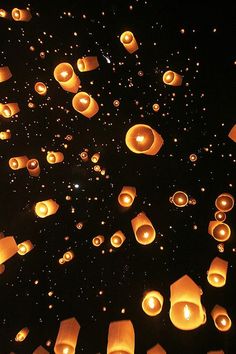 many lanterns floating in the air at night