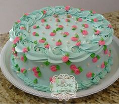 a cake with frosting and pink roses on it