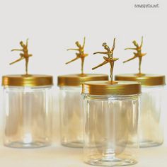 three glass jars with tiny gold figurines in them