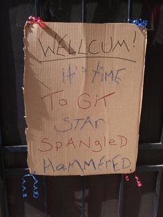 a cardboard sign that is attached to a gate