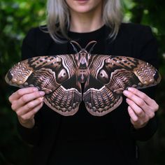 a woman holding a butterfly in her hands