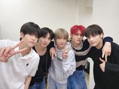 four young men posing for the camera with their fingers in the air