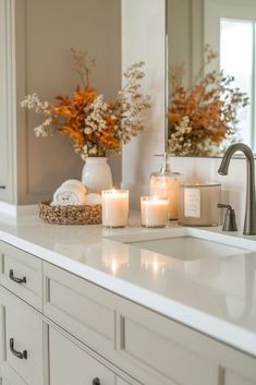 candles sit on the counter in front of a mirror