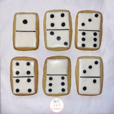 cookies decorated with white and black icing are arranged in the shape of dominos