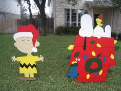 two cardboard christmas decorations sitting in the grass