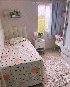 a bed room with a neatly made bed next to a window and a rug on the floor