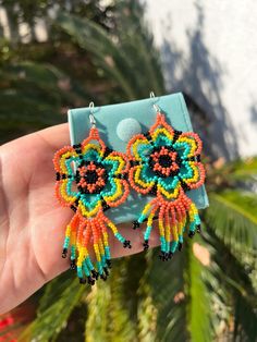 Huichol beaded flower earrings are carefully made by talented hardworking artisans in Mexico. A beautiful accessory to match any outfit and embrace the artistry behind this creation Each set comes with a protective jewelry case Measurements: -Flower + strings: 4" -Length: 4 1/2" Traditional Flower Earrings For Festival, Traditional Flower Shaped Earrings For Festivals, Traditional Flower-shaped Earrings For Festivals, Multicolor Flower Beaded Earrings For Festival, Festival Multicolor Flower Beaded Earrings, Multicolor Floral Beaded Earrings For Festivals, Traditional Multicolor Flower Earrings, Multicolor Flower Earrings For Festival, Traditional Flower Shaped Beaded Earrings For Festivals