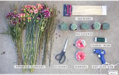 flowers, scissors and other items laid out on the ground to be used for flower arranging