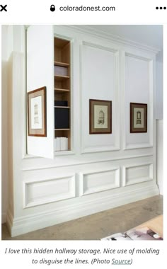 an empty room with white painted walls and framed pictures on the wall, along with bookshelves