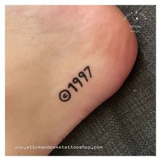 a person with a small tattoo on their foot that reads 9 19 and has the number nine