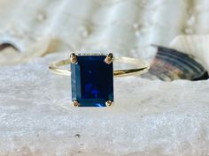 This classic 4 prong setting contains a beautiful 4.00ct. lab created emerald cut sapphire. The stone measures approximately 10x8mm. The stone is accented by a hidden halo which contains .25ct in D color, VVS clarity moissanite. The ring is available in sterling silver, and 14k white, yellow, or rose gold. This ring makes a great promise or engagement ring. Please send me a message if you need a size not listed. This ring can be customized with any color center stone. All items are handmade by m Classic Octagon Lab-created Sapphire Ring, Classic Rectangular Sapphire Ring, Classic Rectangular Lab-created Sapphire Ring, Classic Square Cut Sapphire Ring As Gift, Classic Square Cut Sapphire Ring Gift, Classic Sapphire Square Cut Ring As Gift, Classic Emerald Cut Sapphire Birthstone Ring, Classic Sapphire Ring With Rectangular Stone, Classic Sapphire Emerald-cut Ring