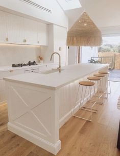 a kitchen with an island and bar stools next to the counter top in front of it