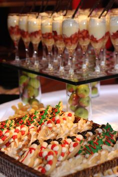 several desserts are arranged on a table with wine glasses in the backgroud