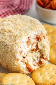 a cracker filled with chicken salad on top of a plate next to carrots