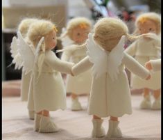 several little angel figurines holding hands on a table